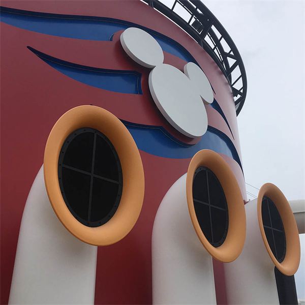 The red funnel of a Disney Cruise Line ship, with the Mickey silhouette above three orange-rimmed portholes.